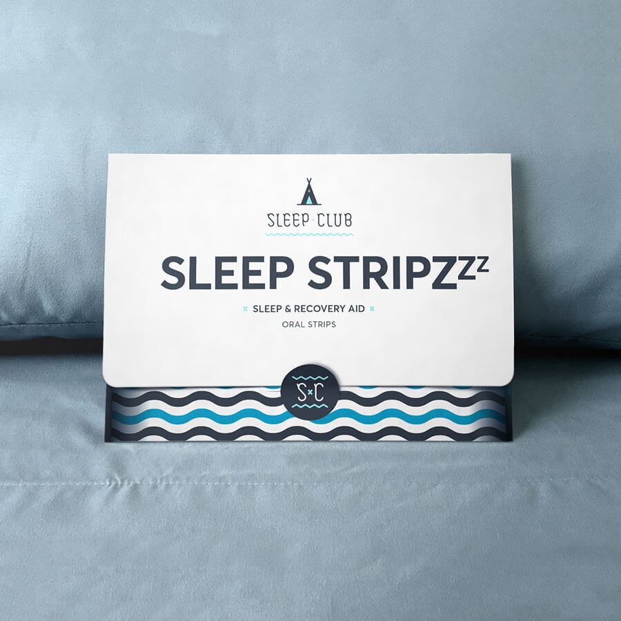 Sleep Stripzzz sleep aid envelope package sitting on a bed. Sleep Club, Sleep Stripzzz, Sleep and Recovery Aid, Oral Strips is printed on the front.